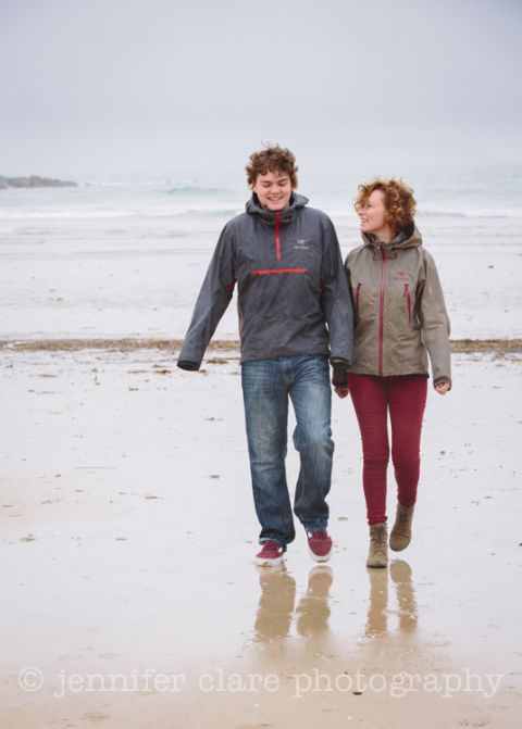 photograph of mother and son walking on a rain swept beach in Cornwall
